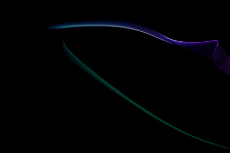 Mystify screensaver: smooth teal and violet ribbons sweeping across a black screen
